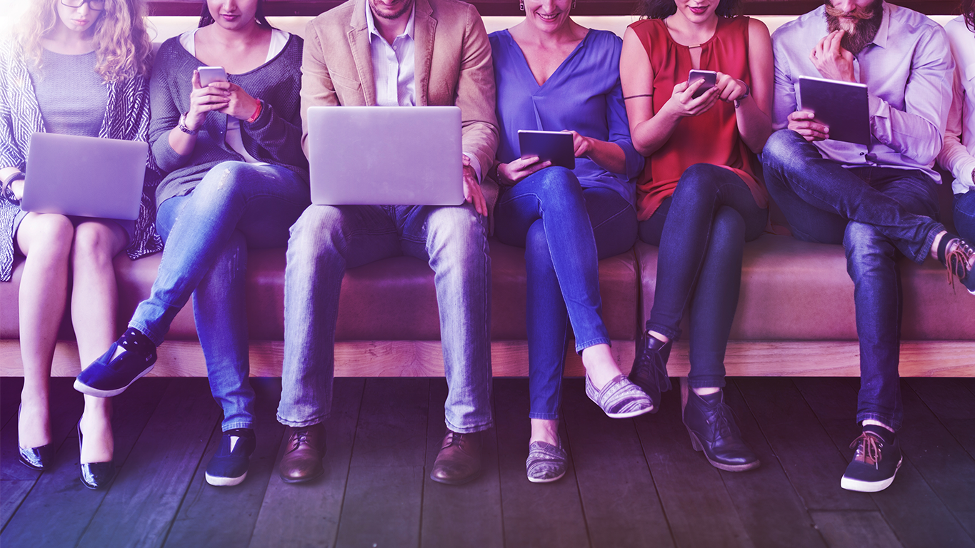 The Candidate Journey: 6 people sit on a bench with various devices in their hands including laptops, phones and ipads.